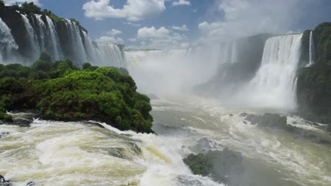 vista pintoresca en cámara lenta del increíble paisaje rocoso del borde del acantilado en la caída de iguazu, destino argentino, américa del sur, dramáticas olas chocando contra el piso rocoso de la piscina desde el enorme valle de la cascada