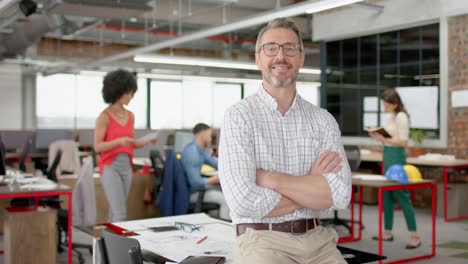 portrait of caucasian man with arms crossed smiling at office