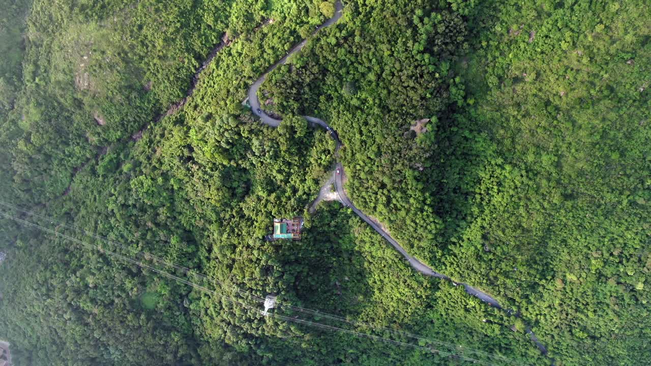 vista aérea de una estrecha y sinuosa carretera de montaña rodeada de una exuberante naturaleza verde