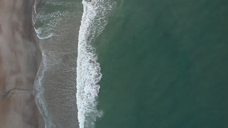 downward angle drone shot of ocean with calm waves