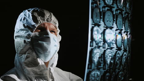 doctor in protective clothing looks at the results of the patient's examination 2