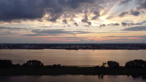 Vista-Aérea-De-La-Tranquila-Puesta-De-Sol-Con-Nubes-Sobre-El-Río-San-Lorenzo,-Canadá-Con-La-Silueta-De-La-Orilla-Del-Río