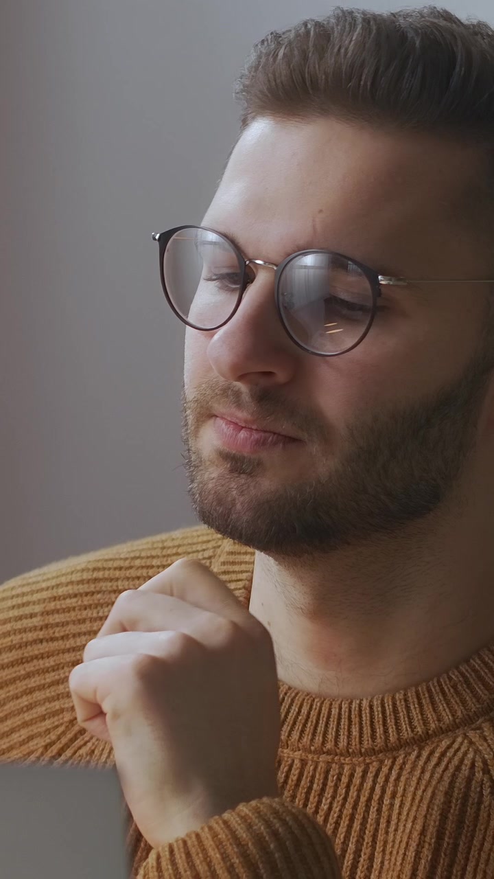 Uomo concentrato con gli occhiali che riflette profondamente mentre lavora
