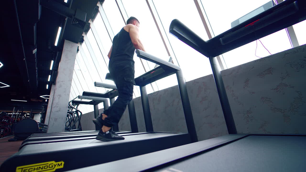 Sporty man running at gym. Fit man running on treadmill in the gym