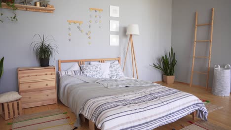 bedroom set with cozy accessories in the scandinavian style. a bed with a large number of pillows, soft carpets and blankets.