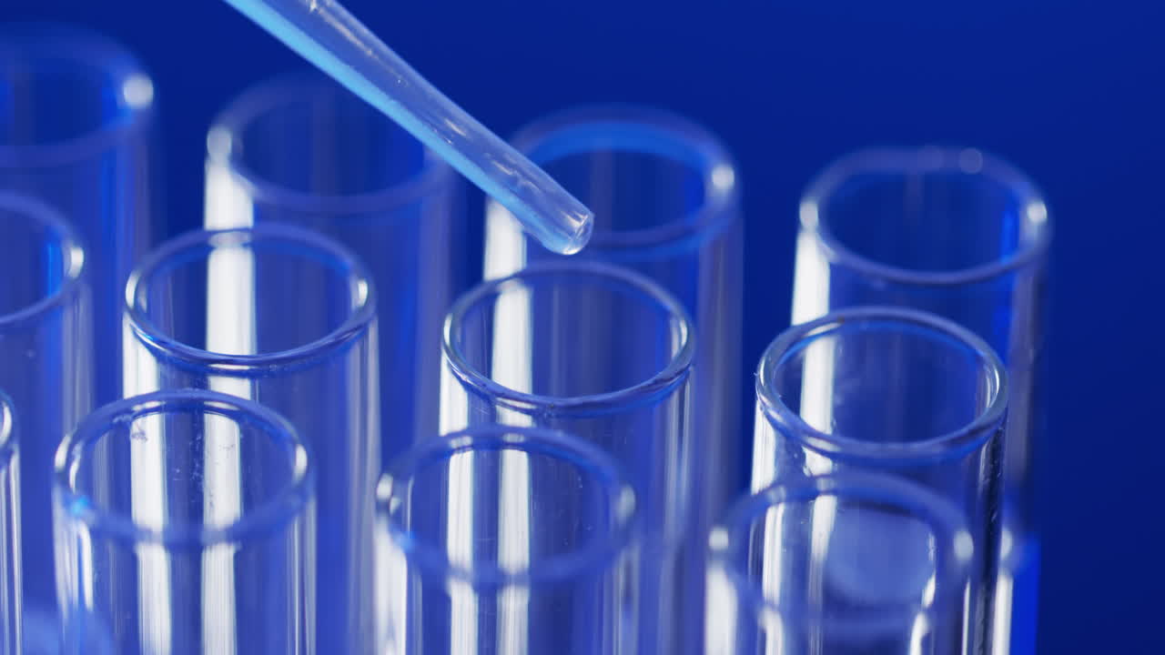 vídeo de la pipeta de laboratorio y los tubos de ensayo con espacio de copia sobre fondo azul