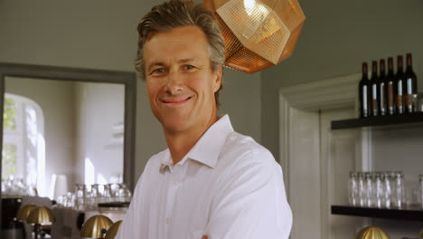 portrait of happy man standing with arms crossed