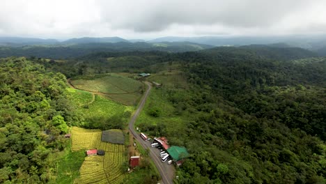 Costa-Rican-Farmland-in-Rainforest-jungle-with-cloudy-sky--Aerial