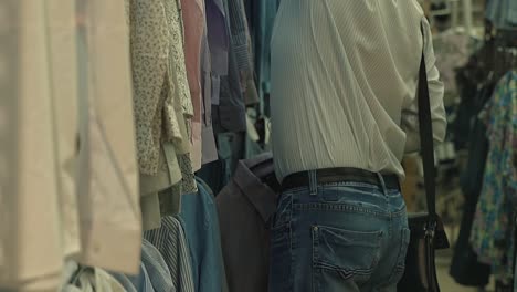 man chooses a shirt in the supermarket