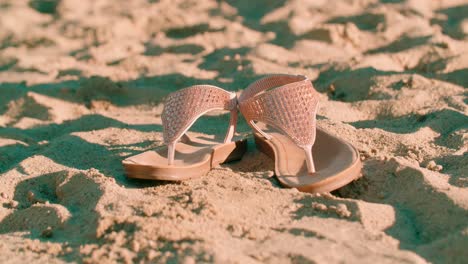 dropping female footwear on the dry sand from the drop