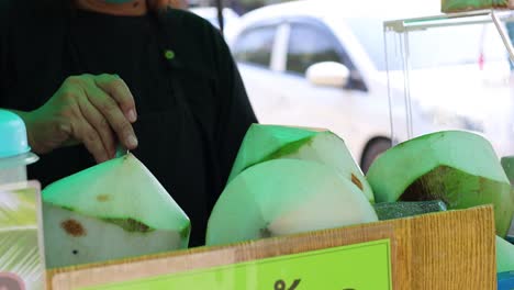 person skillfully opening and serving coconut water