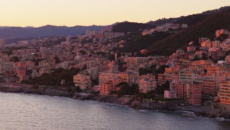 colorful buildings along the coastline of genoa, italy, at sunset, aerial view