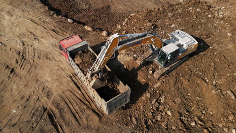 excavator loading dump truck on construction site