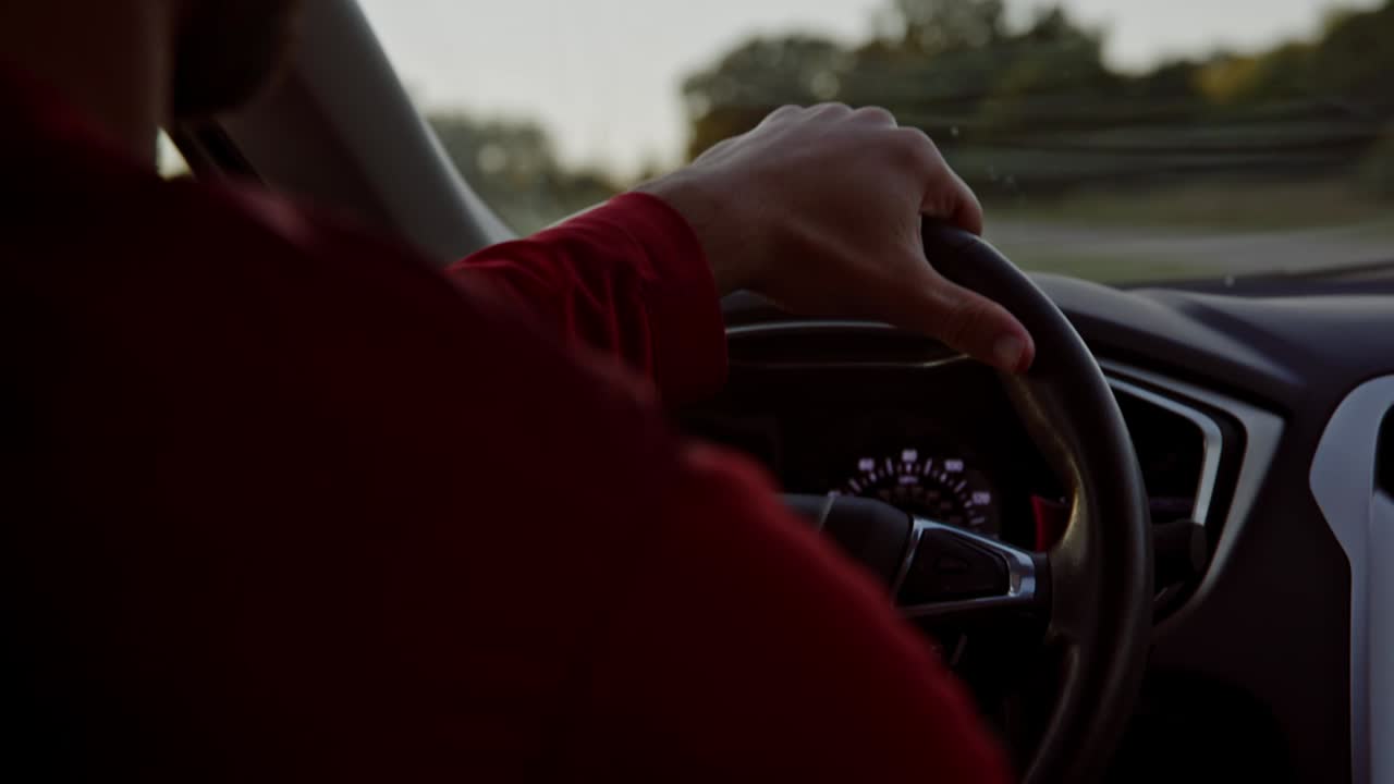 한 손으로 운전대를 잡고 운전하는 남자