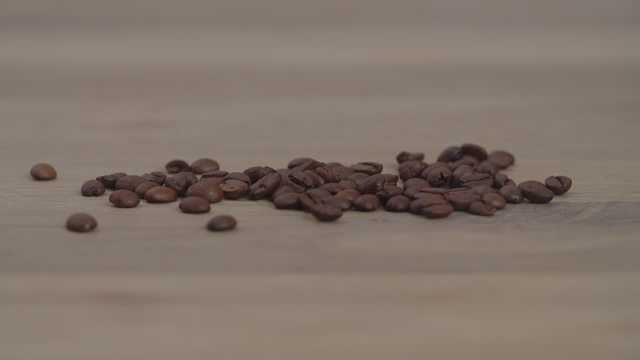 느린 속도로 드럼 로스터에서 회전하고 혼합하는 브라운 로스터 커피 원두의 슬로우 모션 시네마틱 아름다운 샷을 닫습니다.