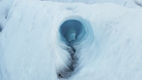 ice tunnel created by water erosion inside frozen glacier, global warming