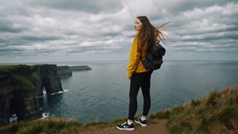 woman admiring the scenic view from the cliffs of moher
