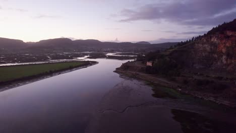 Evening-magneta-sky-over-low-tide-coastal-mudflats-estuarine-landscape-AERIAL