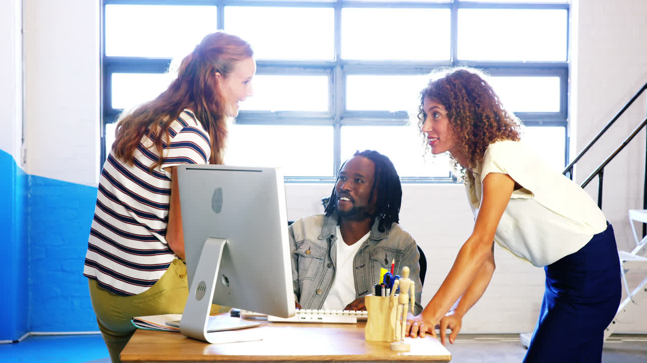 Colleagues looking at computer and discussing with each other