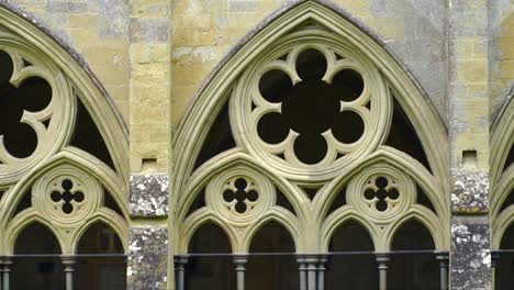 detailed close-up of pointed gothic arches and intricate stone tracery in the cloister of salisbury cathedral, an architectural landmark in wiltshire, england.