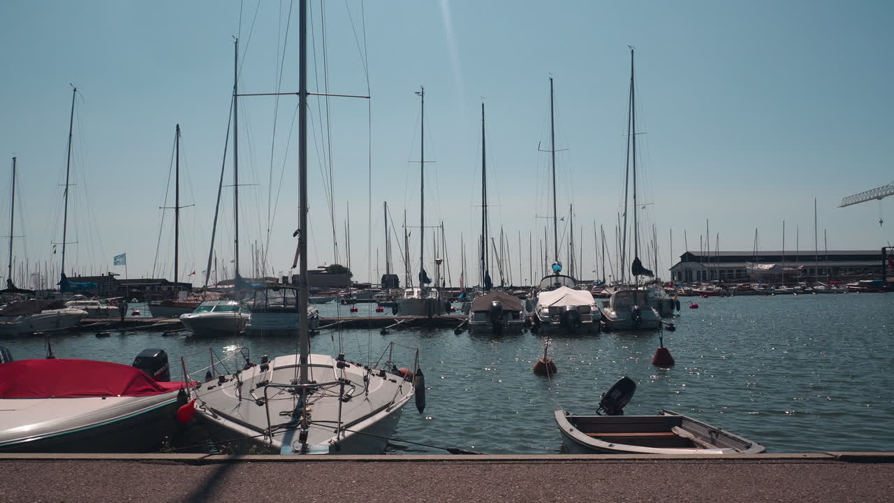 Laufende Menschen im Hafen mit festgemachten Yachten und Booten