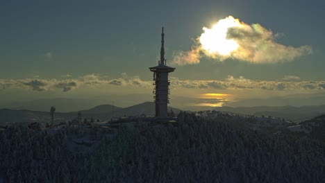 Antenne---Telekommunikationsturm-Auf-Dem-Schneebedeckten-Berg-Parnitha-Mit-Sonnenbeschienener-Stadt-Im-Hintergrund---Aufnahme-Auf-DJI-Inspire-2-X7-Raw