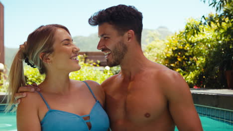 portrait of smiling couple on holiday in swimming pool