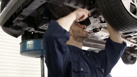 un guapo mecánico reparando un coche