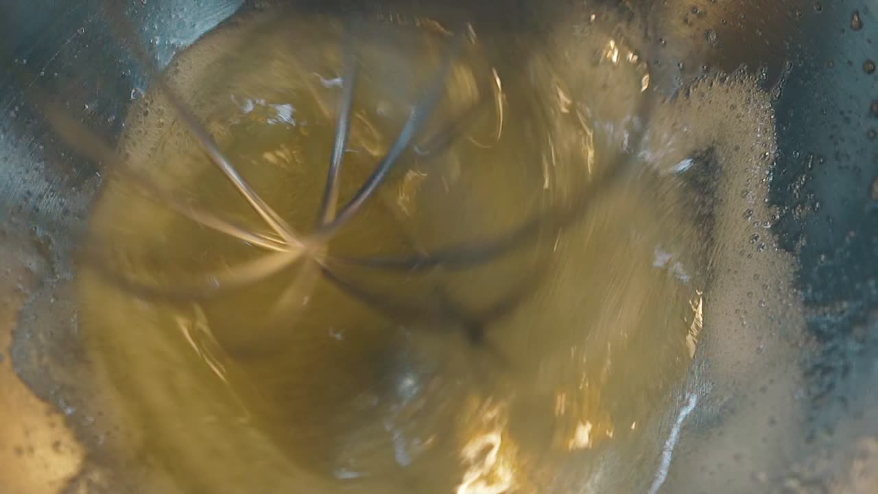 el mezclador eléctrico mezcla azúcar y huevos haciendo crema en el tazón