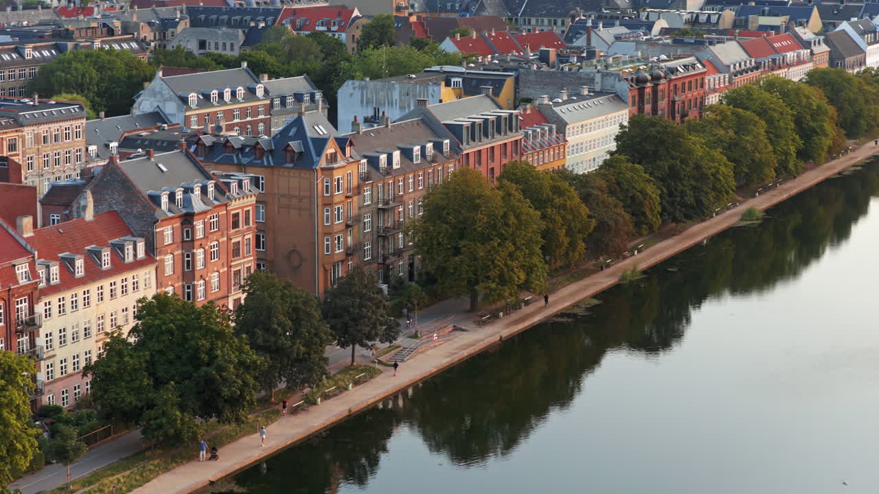 Vista aerea da drone degli appartamenti sul lago lungo Sortedams So con persone che passeggiano vicino all'acqua a Copenaghen, Danimarca