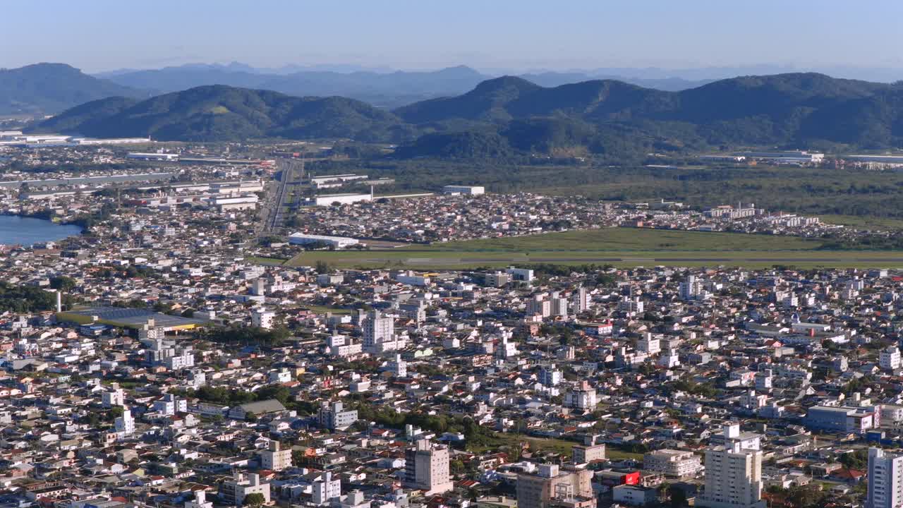 Close-up aerial image of Navegantes International Airport with the city and mountains in the background, Santa Catarina, Brazil