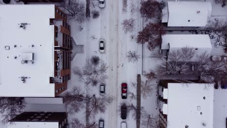Top-down-drone-shot-of-the-street-entirely-covered-with-snow-and-parked-cars-in-Calgary