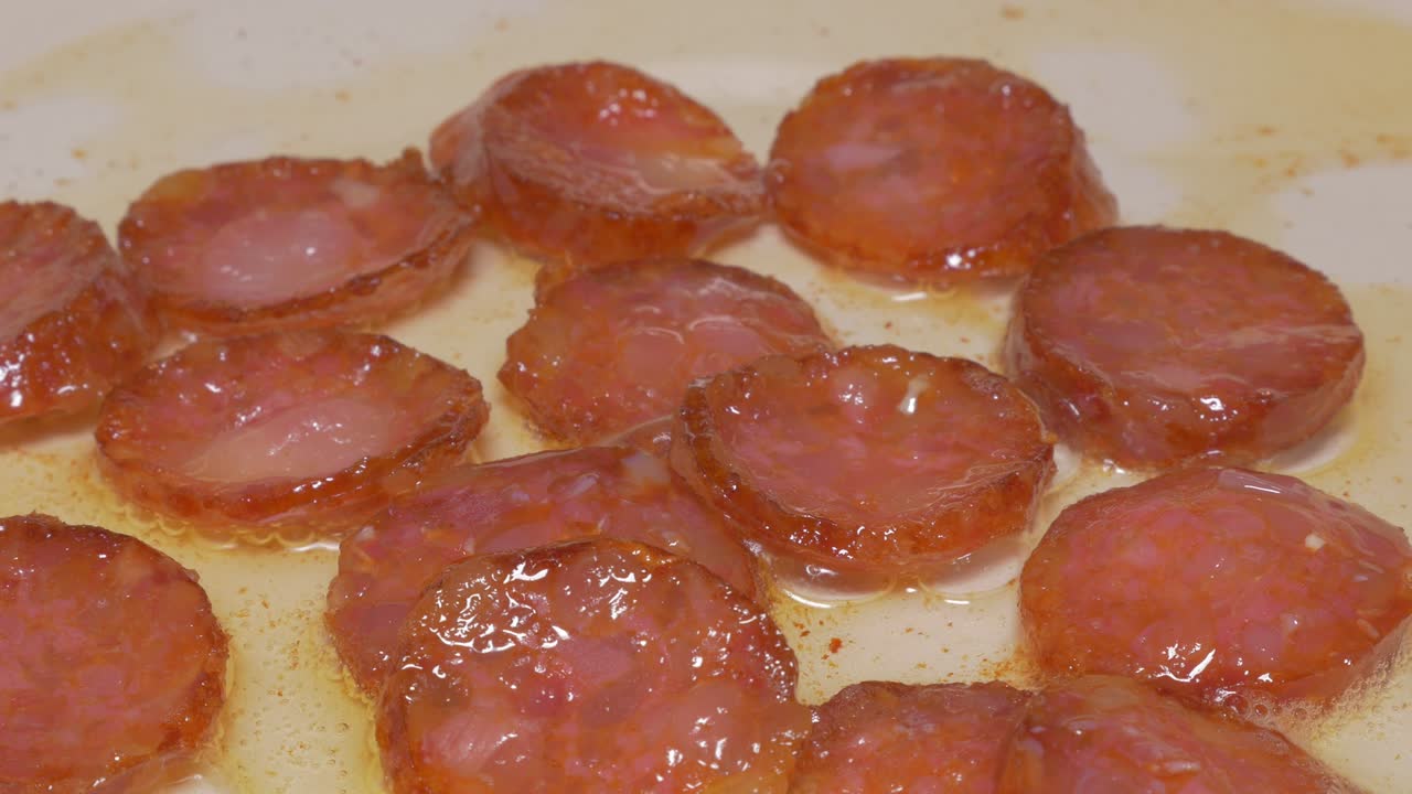 cortes de salchichas fritos en aceite primer plano 4k