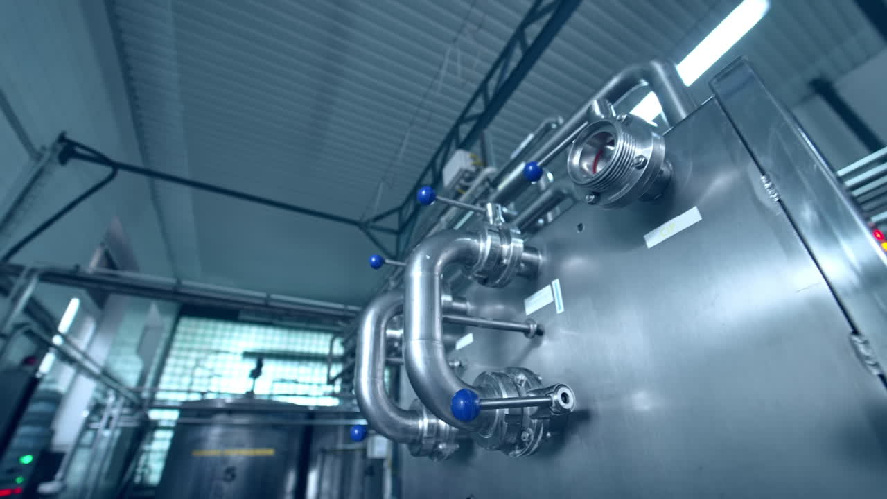 Dairy factory with milk pasteurization tank and pipes. Motion camera view