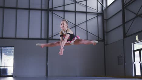 teenage female gymnast performing at sports hall