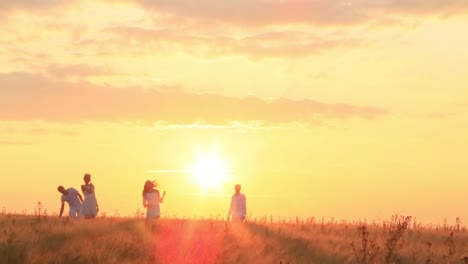 sunset over a wheat field with people