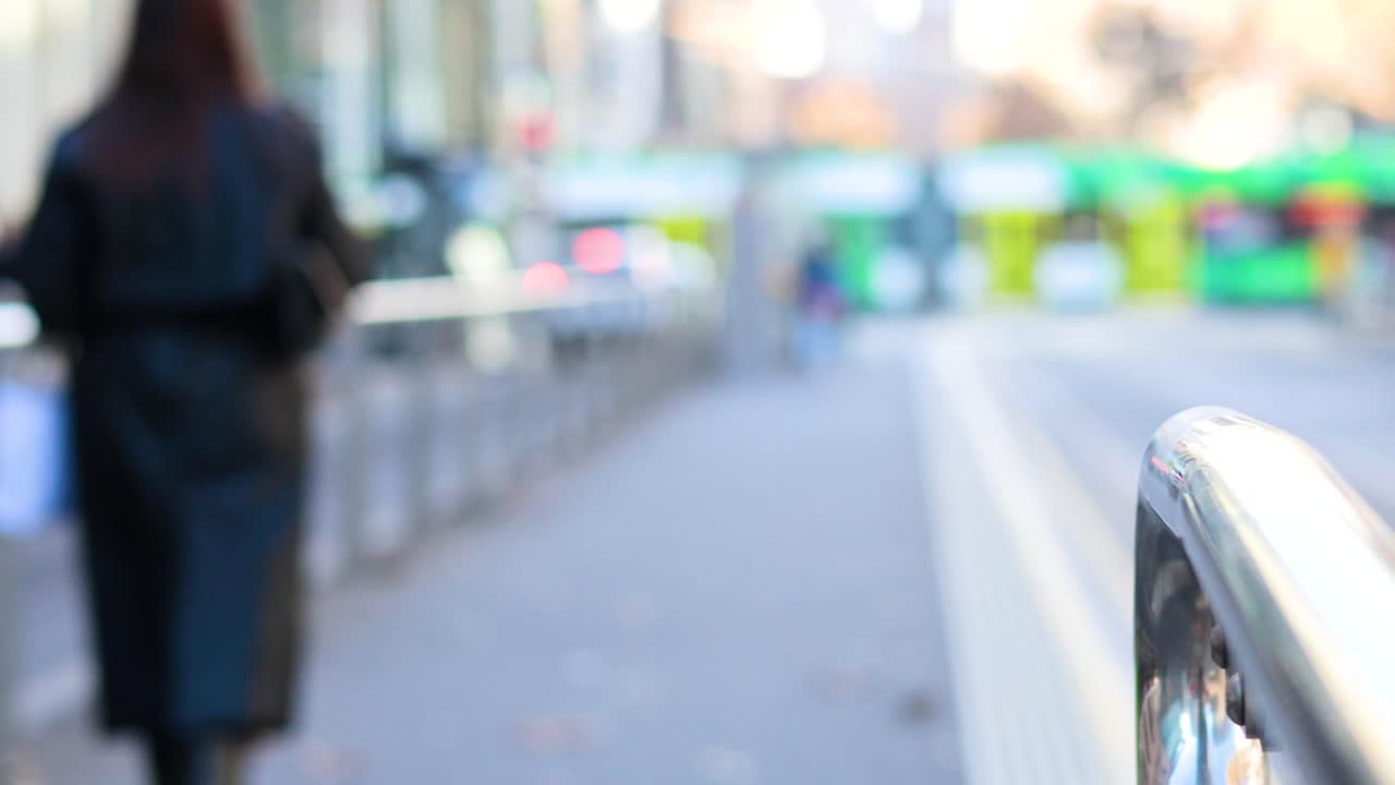 한 여자 가 바쁜 거리 를 따라 고 있다