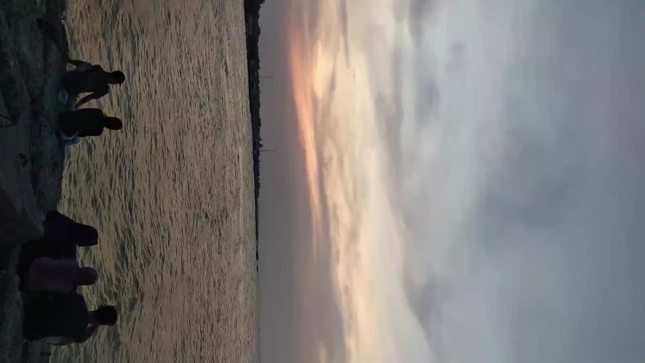 gente disfrutando del espectacular cielo crepuscular sobre la playa