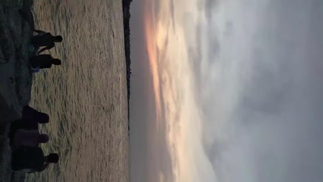 gente disfrutando del espectacular cielo crepuscular sobre la playa