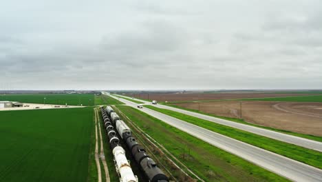 ferrocarril con tren cerca de la carretera en campos verdes