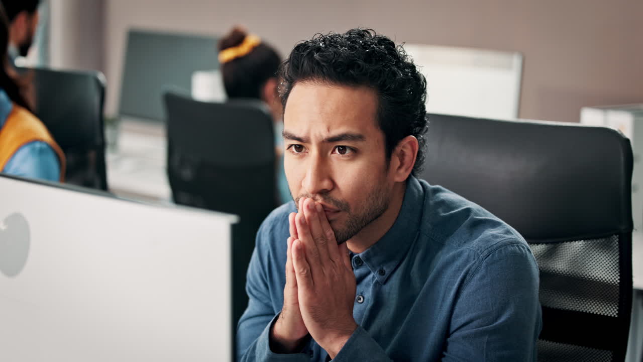 Thoughtful Businessman Concentrating at His Desk in a Modern Office