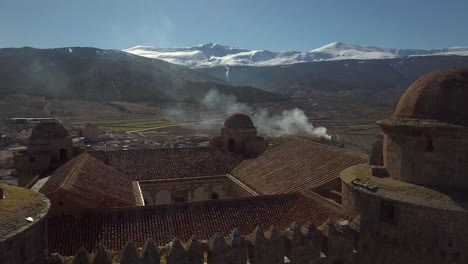 aerial ascending view over the castle of la calahorra with sierra nevada behind