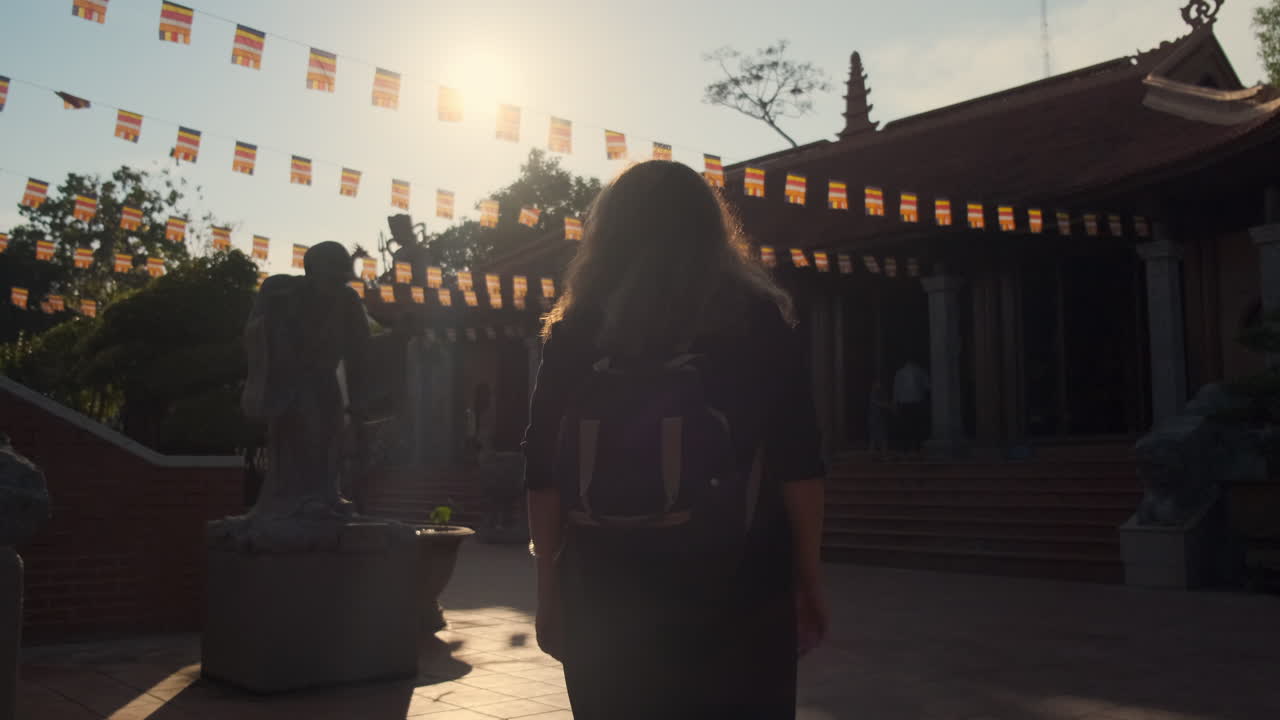 Woman Visiting a Buddhist Temple at Sunrise/Sunset
