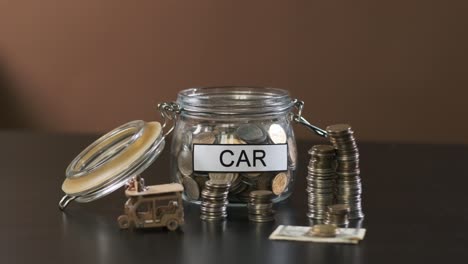 man puts coin into glass with inscription car