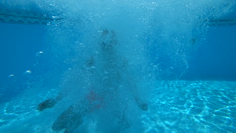 Hombre-Con-Pantalones-Cortos-De-Natación-Naranja-Salta-A-La-Piscina-En-Cámara-Lenta