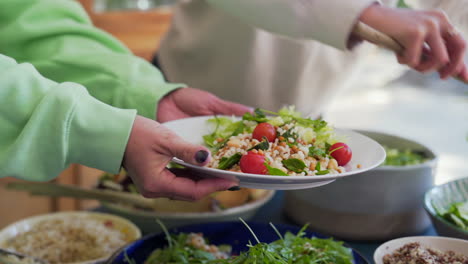 fresh vegan salad being served on a plate at a group meal