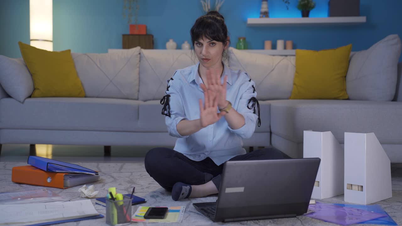 una mujer trabajadora de oficina en casa mirando a la cámara con una severa advertencia enojada.