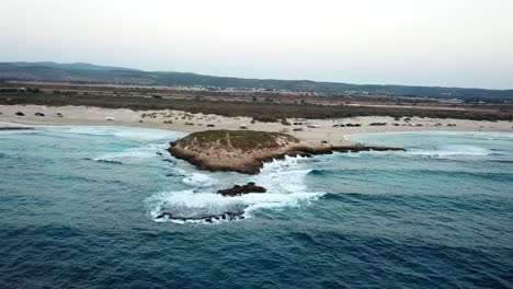 costa aislada de arena y una pequeña isla aislada de roca