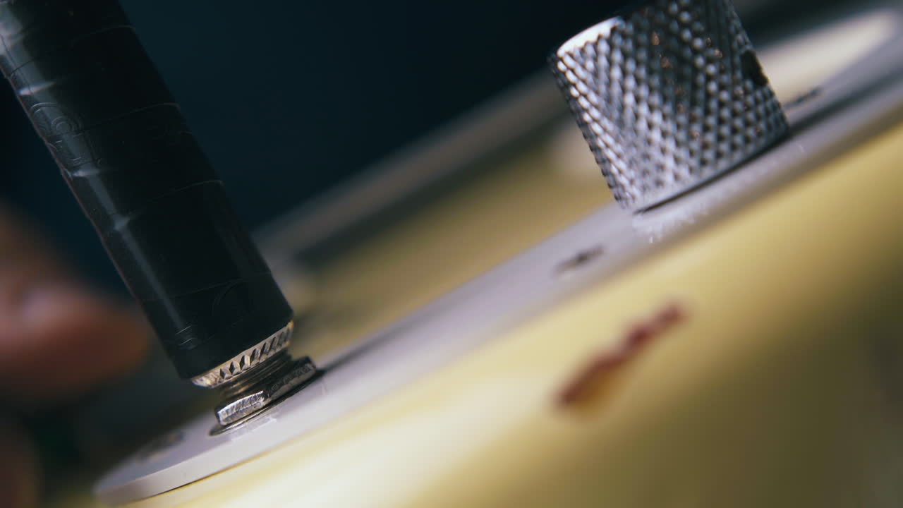 숙련된 음악가는 4분의 1인치 증폭기 잭을 연결합니다.