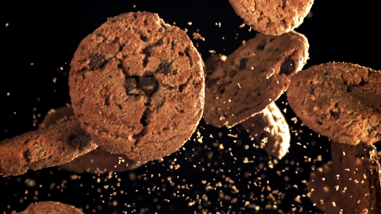Biscotti con gocce di cioccolato che cadono al rallentatore con briciole